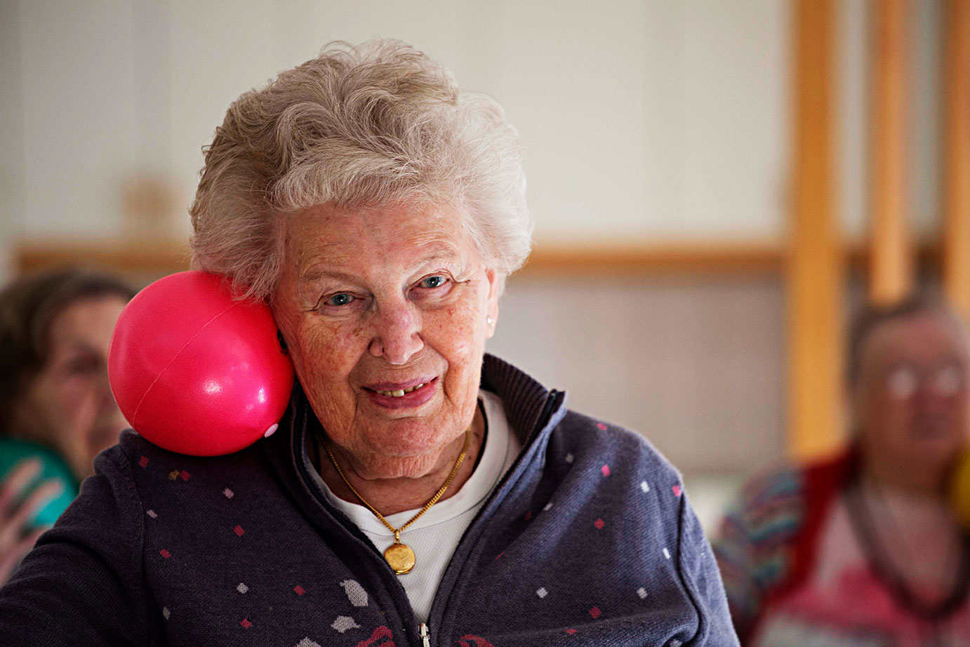 Äldre kvinna som balanserar en boll